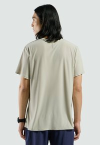 Beige T-shirt met korte mouwen van een gladde stof, met een subtiele textuur en logo-detail op de achterkant. Casual pasvorm, ronde hals.