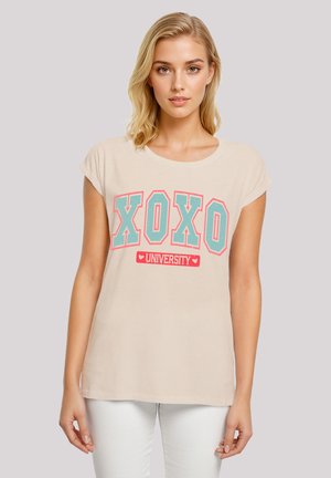 Helles beige T-Shirt mit kurzen Ärmeln, das einen großen blauen "XOXO"- und einen roten "UNIVERSITY"-Grafikdruck zeigt. Aus weichem Baumwollmaterial.