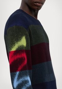 Strickpullover mit vertikal gerippter Struktur, mehrfarbigem Streifendesign in Marineblau, Grün, Burgunderrot und Blau mit abstrakten Mustern.