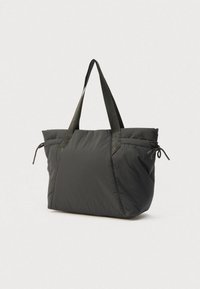 Sac cabas en tissu noir avec une finition douce et texturée. Il comporte deux poignées robustes et des détails à cordon de serrage sur les côtés.