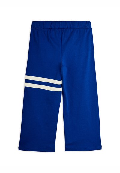 Μπλε παντελόνι με ελαστική μέση και δύο οριζόντιες λευκές ρίγες στο αριστερό μηρό, σε μήκος έως τον αστράγαλο, κατασκευασμένο από μαλακό ύφασμα.