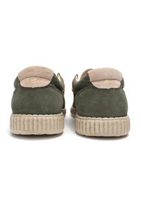 Zapatos de ante verdes con un cuello acolchado beige y suelas de goma beige texturizadas. Presentan un símbolo bordado en la parte posterior.