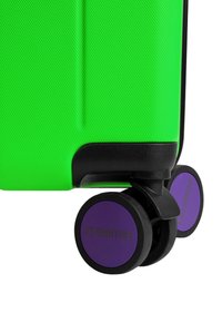 Groene harde koffer met textuur, zwarte accenten en vier paarse wielen. Opvallend merklogo op het wiel.