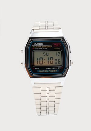 Casio digitális karóra ezüst fém szíjjal, 10:10:06-ot mutat, ébresztővel, stopperrel, vízállósággal és lítium elemmel.
