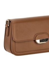 Brun läderhandväska med en slät yta, utrustad med klaffstängning och guldfärgade metallaccenter. Kompakt design och rektangulär form.