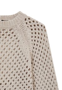 Maglione chunky beige a maglia lavorata con un motivo a tessitura aperta e colletto a girocollo a coste, che mette in mostra la parte superiore della spalla e dell manica.