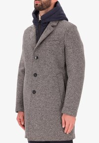 Cappotto di lana grigio con un design strutturato, tre bottoni, tasche laterali e un cappuccio imbottito blu navy sovrapposto per un ulteriore calore.