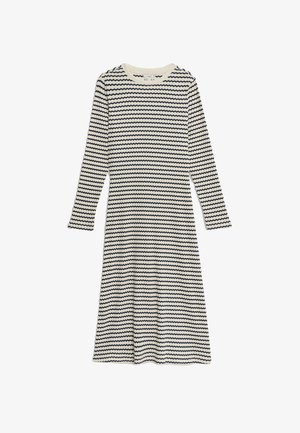 Robe à manches longues avec des rayures zigzag crème et marine, décolleté rond, silhouette fluide et texture de tissu douce.