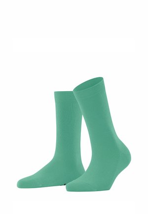 Chaussettes en coton vert clair avec une texture lisse, longueur mi-mollet, et bords côtelés. Comprend des zones de talon et de orteil renforcées.