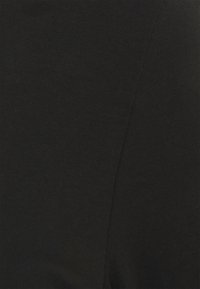 Černá ribovaná tkanina, detailní pohled. Vyznačuje se hladkou texturou a jednotnou barvou bez viditelných vzorů nebo akcentů. Lehká a přiléhavá.