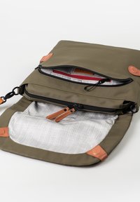 Borsa verde oliva con dettagli in pelle, molteplici scomparti con cerniera e una fodera interna a scacchi. Presenta materiale goffrato e ferramenta robusta.