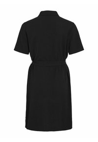 Trumpos juodos suknelės su apykakle, trumpomis rankovėmis, diržu ant liemens ir lygiu, vientisu audiniu. Suknelė yra iki kelių ilgio.