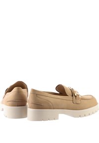 Loafers en cuir beige avec une boucle décorative en ton doré, bout rond et semelle épaisse en caoutchouc blanc avec des détails de motif en relief.