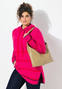 Fuksjowy sweter z kapturem w czerwone poziome paski, z troczkami i granatowymi akcentami. Uzupełniony beżową torbą typu tote.