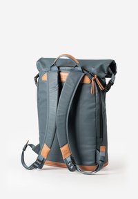 Blauer Roll-Top-Rucksack mit beigen Lederakzenten und verstellbaren Gurten. Verfügt über einen Reißverschluss, textilen Material und eine strukturierte Silhouette.