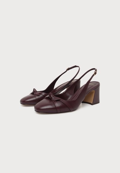 Ζευγάρι μπορντό slingback παπούτσια με χοντρό τακούνι, χαμηλά λουράκια, στρογγυλεμένες μύτες και διακοσμητικό φιόγκο μπροστά, τοποθετημένα σε λευκό φόντο.
