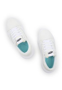 White suede sneakers with a smooth texture, lace-up design, light blue insoles, and a black Vans logo on the tongue.