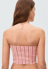 Stropeløs cropped top i et tekstureret stof med pink og lilla striber. Designet har en tætsiddende silhuet og en lige kant.