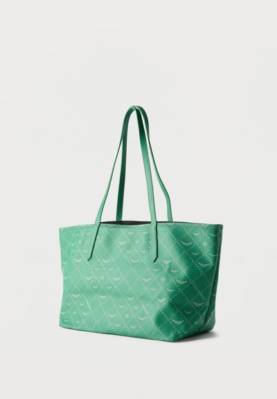 Πράσινη τσάντα tote με υφασμένο μοτίβο διαμαντιού και ημισελήνου, με μακριά λουριά ώμου σε λευκό φόντο.