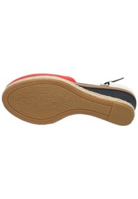 Espadrille de cuña con un upper multicolor en rojo, blanco y azul marino. Cuenta con una suela de goma texturizada y una entresuela envuelta en yute.