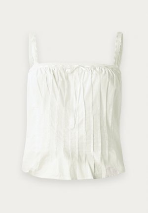 Valkoinen hihaton toppi, jossa on ohuet olkaimet, ja jota koristavat pleated-tekstuuri ja pitsikoristeet kaula-aukossa.Kevyt puuvillakangas.