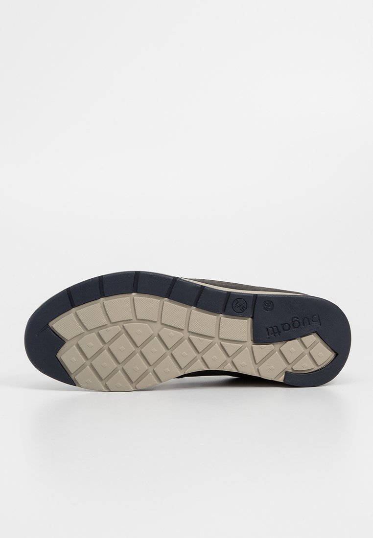 Semelle de chaussure avec un design bicolore ; bleu marine foncé et beige clair. Présente un motif texturé et des crampons rectangulaires pour une meilleure adhérence. Marque visible.