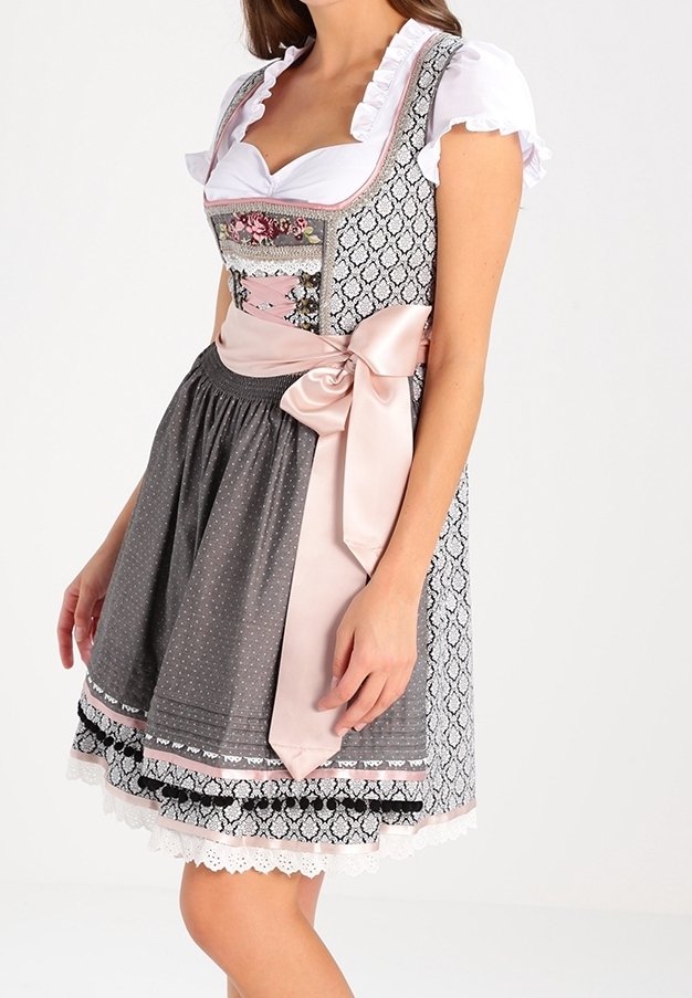 Tradycyjny dirndl z wzorzystym gorsetem z kwiatowymi akcentami, szarym spódnicą w kropki oraz satynową różową kokardą. Falbankowe białe rękawy.