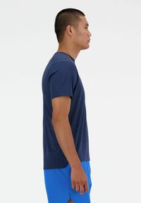 Maglietta atletica a maniche corte di colore blu navy con un motivo testurizzato, scollatura rotonda e vestibilità slim. Abbinata a pantaloni corti blu.