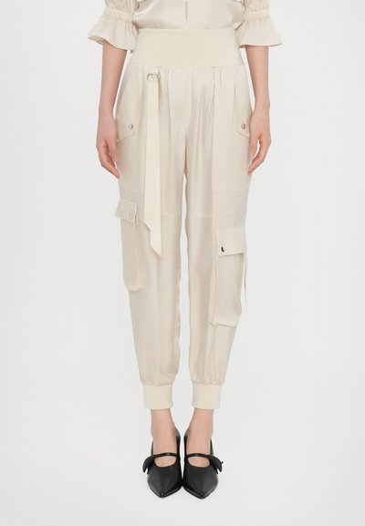 Pantalones cargo beige con una cintura ancha y una corbata ajustable. Cuenta con bolsillos laterales, puños elásticos y una tela suave y ligera.