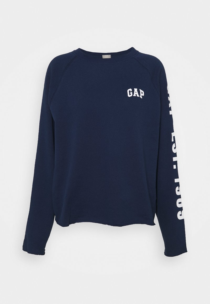 Sweatshirt bleu marine avec le logo "GAP" blanc sur la poitrine et la manche. Présente une coupe décontractée et une texture douce, avec des manches raglan.