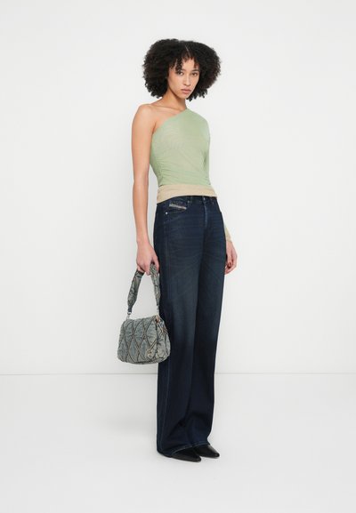 Haut vert asymétrique à une épaule, bande beige ; jean bleu foncé à jambes larges ; sac à main gris texturé avec design matelassé ; chaussures noires à bout pointu.