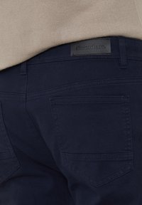 Marineblau Hosen aus strukturiertem Stoff, mit Gesäßtaschen und einem schwarzen Leder-Logo-Patch mit der Aufschrift "threadbare".