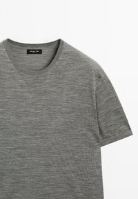 Grå kortærmet T-shirt lavet af blødt stof, med rund halsudskæring og jævn tekstur. Mærket lyder "Massimo Dutti."