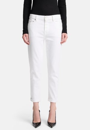 Witte denim jeans met een rechte snit, opgerolde manchetten en voorzakken, gecombineerd met zwarte hoge hakken en een aansluitend zwart topje.