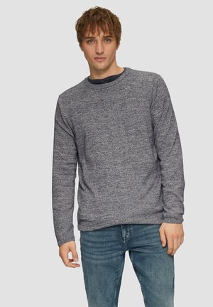 Marine gebreide crew-neck trui met een gestructureerd patroon, voorzien van lange mouwen en een comfortabele pasvorm, gecombineerd met blauwe jeans.