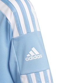 Světlomodrý sportovní dres adidas s bílými pruhy na ramenou a bílým logem na paži. Hladká textura látky.