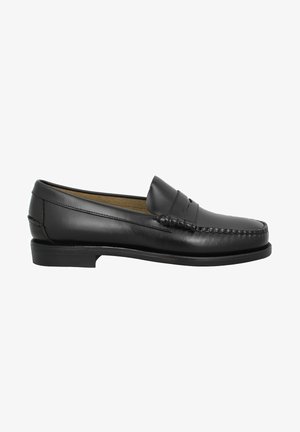 Mocasines de cuero negro con punta redondeada, costuras decorativas y una suela baja y plana. Textura suave, diseño minimalista sin adornos.
