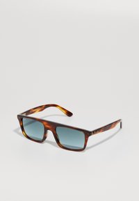 Lunettes de soleil rectangulaires en écaille de tortue avec des verres teintés en bleu et logos Ray-Ban sur les branches et le coin supérieur de la lentille gauche.