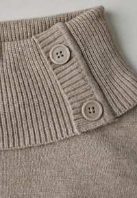 Beige pletený svetr s límcem ribované textury a dvěma světle hnědými knoflíky. Měkká látka s jemným povrchem a subtilními detaily.
