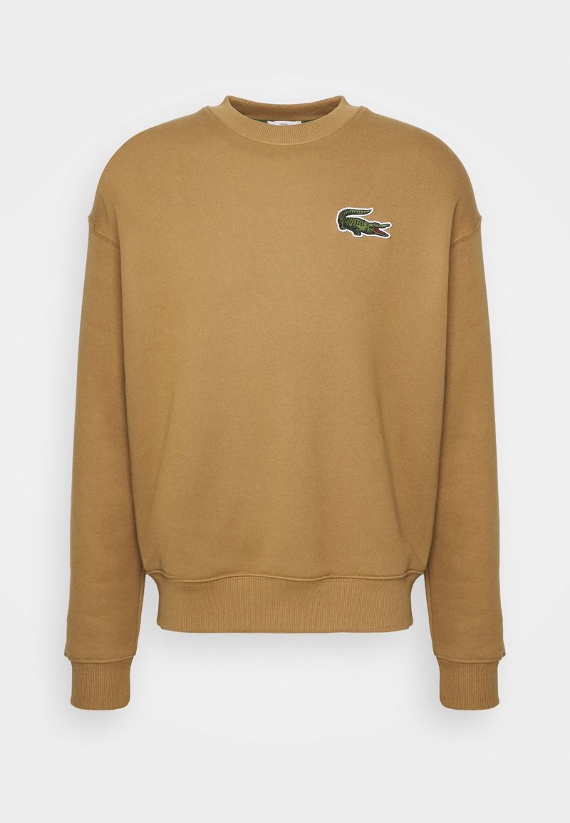 Sweat-shirt marron avec poignets et ourlet côtelés. Présente un petit logo crocodile vert et blanc brodé sur la poitrine. Matière douce.