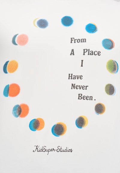 Άσπρο πουκάμισο με κυκλικό μοτίβο από πολύχρωμες κουκκίδες σε αποχρώσεις του μπλε, πορτοκαλί και πράσινου, με το κείμενο «Απ ό έναν τόπο που δεν έχω επισκεφθεί ποτέ.»