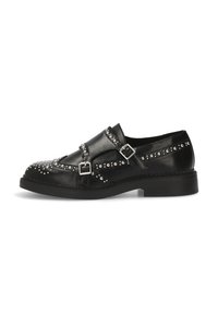 Zapato de cuero negro con dos correas de hebilla, detalles de tachuelas a lo largo de los laterales, punta redonda y una suela negra gruesa.