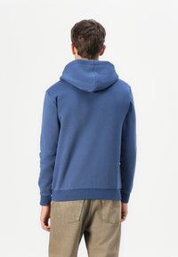 Sudadera con capucha en tejido azul sólido, con un corte relajado, puños y dobladillo acanalados, con una textura suave y sin patrones visibles.