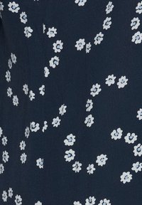 Marine stof met kleine witte en lichtblauwe bloempatronen, met een gestructureerd oppervlak en gelijkmatig verspreide bloemaccenten.