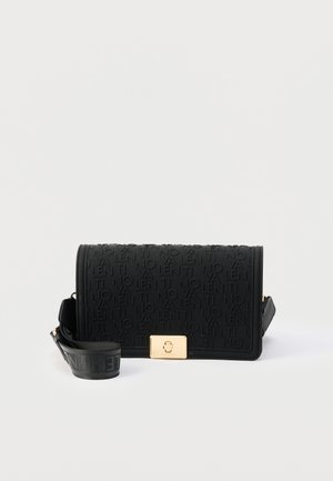 Bolso cruzado rectangular negro con texto repetido en relieve, cierre dorado y correa ajustable enrollada a su lado sobre un fondo blanco.