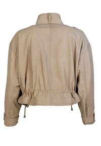 Beige läderkort jacka med en styv krage, elastisk fåll och snörningsdetaljer. Har synliga sömmar och långärmar.