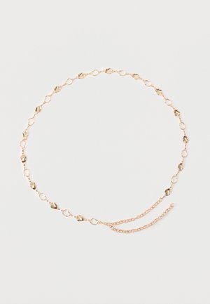 Delikatny złoty pasek łańcuchowy z nieregularnymi, teksturowanymi ogniwami oraz podwójną zapięciem łańcuchowym na białym tle.