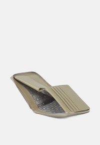 Zip-around wallet in light beige leather with a patterned interior. Features card slots and a smooth texture. Compact rectangular shape.