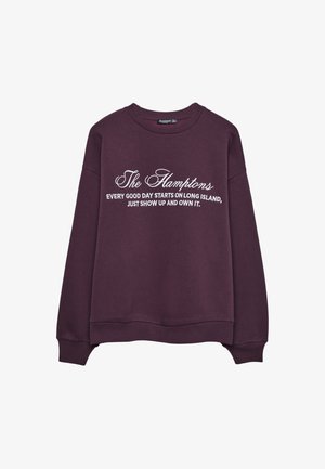 Bordeaux sweatshirt, ronde hals, losse pasvorm. Voorzien van witte tekst: "The Hamptons" en "Elke goede dag begint op Long Island, kom gewoon opdagen en maak het je eigen."
