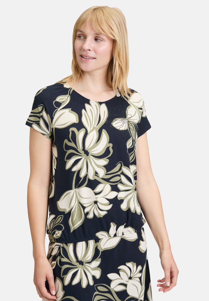 Marineblauwe blouse met een bloemenpatroon in crème en olijfgroen, met korte mouwen, een ronde halslijn en een gatherende zoom.